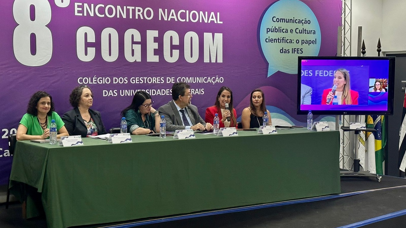 Imagem mostra Maíra Bittencourt discursando durante a mesa de abertura do 8º Encontro Nacional Cogecom