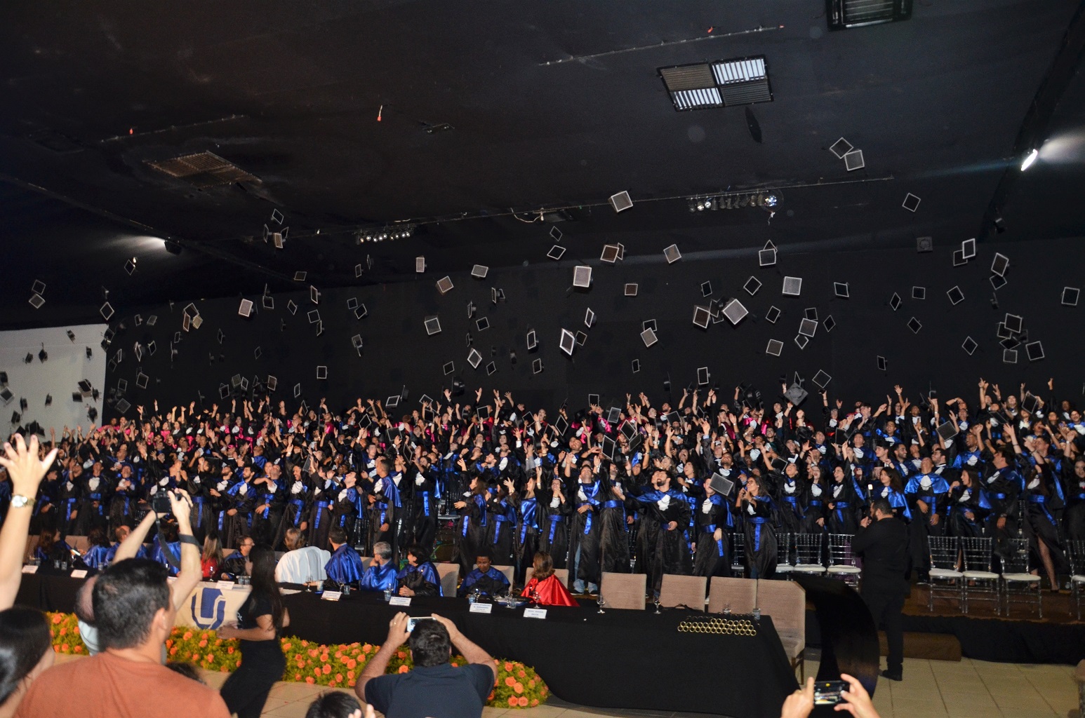 Foto de colação de grau da UFU, com formandos jogando seus capelos para o alto