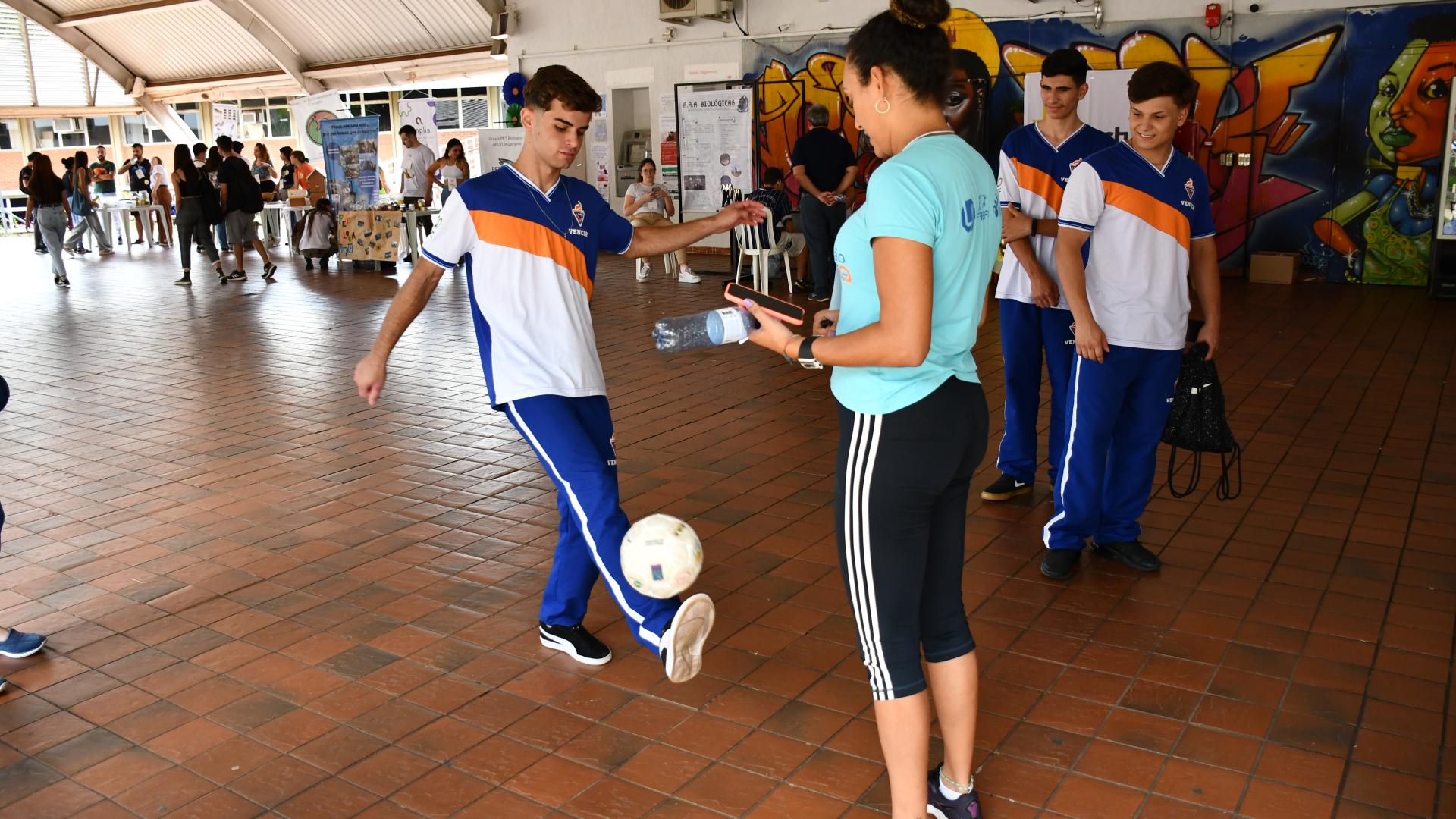 Estudante fazendo embaixadinha com uma bola de futebol 