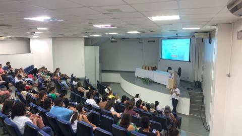 Foto mostra um auditório com participantes do evento
